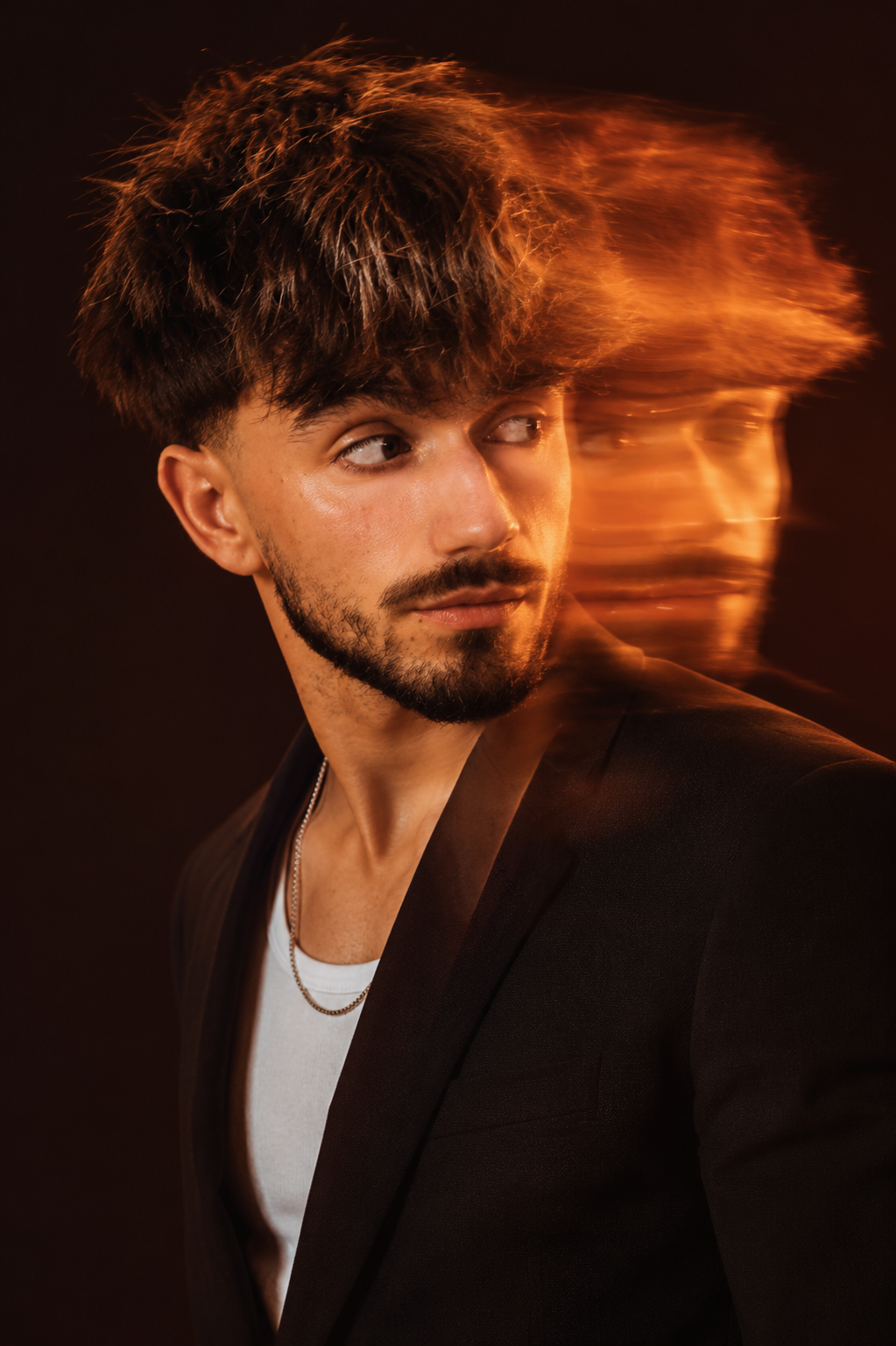 Portrait créatif du fondateur de Delra Studio, veste orange et lunettes teintées